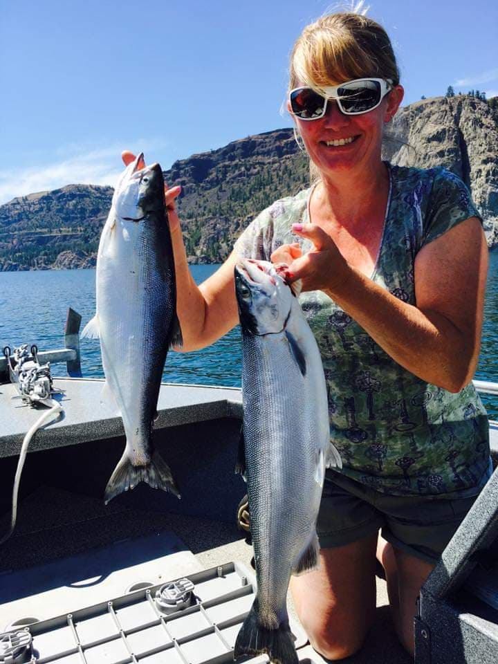 Woman holding two freshly caught fish